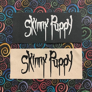 May include: Two iron-on patches with the text "Skinny Puppy" in a dripping font. The top patch is black with white text. The bottom patch is beige with black text.