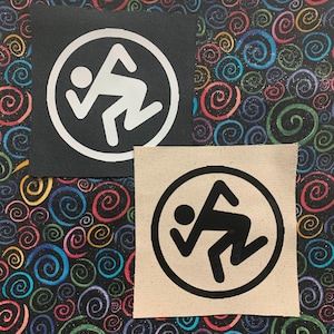 Op de afbeelding: Twee strijkbare patches met het zwart-witte logo van de band The Offspring. Het logo is een gestileerd stickfiguur in een cirkel. Eén patch is op een zwarte achtergrond en de andere op een beige achtergrond.