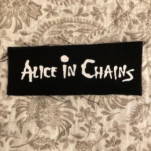 Może przedstawiać: Zestaw trzech ceramicznych kubków z nakrapianym, matowym wykończeniem. Kubki są w odcieniach kremu, jasnoszarym i ciemnoszarym. Każdy kubek ma prosty, minimalistyczny design.