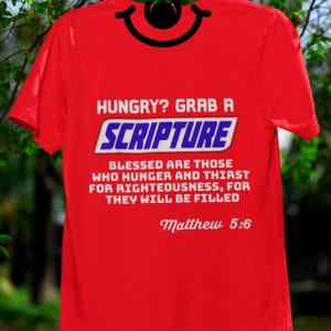 Puede incluir: Camiseta roja con texto blanco: "HUNGRY? GRAB A SCRIPTURE". Debajo, el texto dice: "BLESSED ARE THOSE WHO HUNGER AND THIRST FOR RIGHTEOUSNESS, FOR THEY WILL BE FILLED" y "Matthew 5:6".