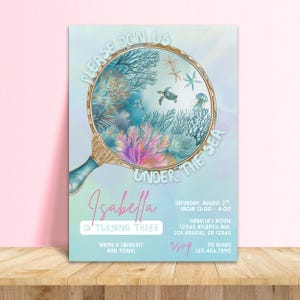 Puede incluir: Una invitación con temática submarina. El diseño presenta una lupa con coral, una tortuga y el texto "Please Join Us Under The Sea". La invitación es para el 3er cumpleaños de Isabella, con detalles del evento.