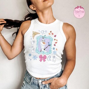 May include: White tank top featuring a cartoon image of Olaf from Frozen, framed with a light blue border. The design includes snowflakes, a pink bow, and the text "TylerPrint" in a pink circle.