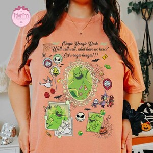 May include: Peach-colored t-shirt featuring a graphic design with the text "Oogie Boogie Bash" and other phrases. The design includes illustrations of characters and elements from a Halloween-themed movie, such as Oogie Boogie, Jack Skellington, and bats.