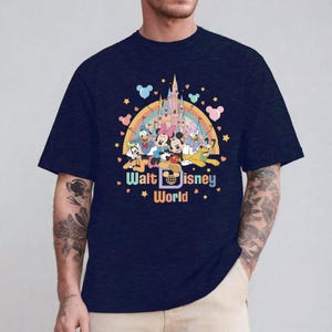 May include: A navy blue t-shirt with a colorful graphic of Mickey Mouse and friends in front of Cinderella's Castle. The graphic also includes a rainbow and the text "Walt Disney World".