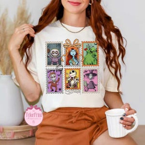 Puede incluir: Camiseta color crema con seis dise&ntilde;os de sellos postales con personajes de The Nightmare Before Christmas. Los sellos muestran personajes como Sally, Jack Skellington y Oogie Boogie. La camiseta tiene cuello redondo y mangas cortas.