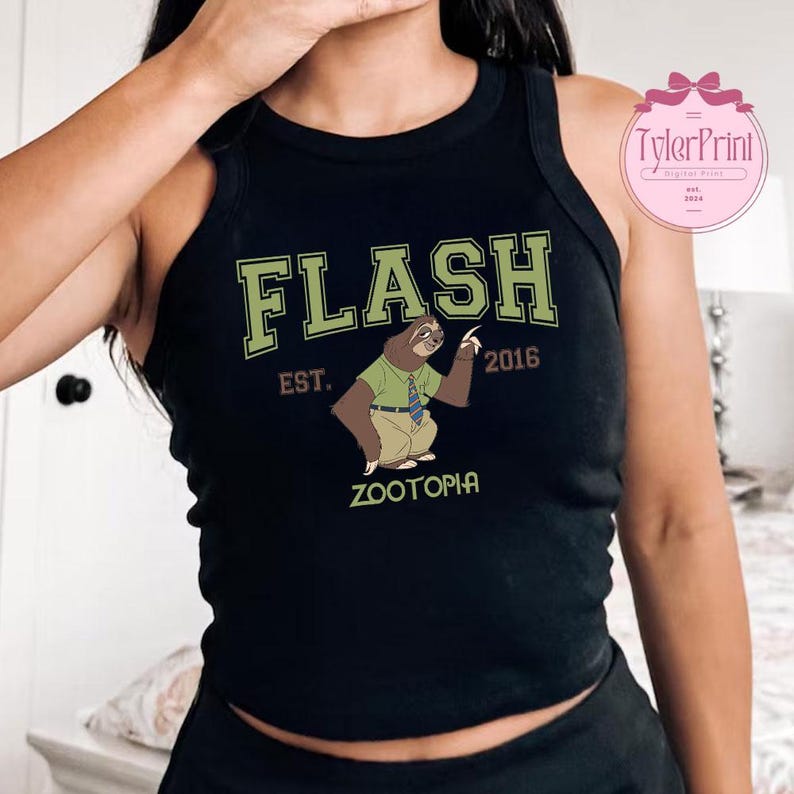 May include: Black tank top featuring a cartoon sloth character from Zootopia, with the word "FLASH" in green block letters. Below the sloth illustration are the words "EST. 2016" and "ZOOTOPIA". The tank top has a racerback design.