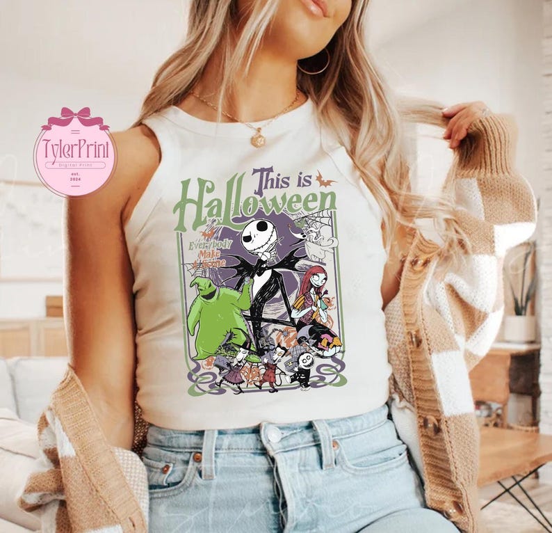 K&ouml;nnte beinhalten: Wei&szlig;es Tanktop mit einer farbenfrohen Grafik aus "The Nightmare Before Christmas". Das Design zeigt Jack Skellington, Sally, Oogie Boogie und andere Charaktere mit dem Text "This is Halloween". Das Tanktop ist &auml;rmellos.