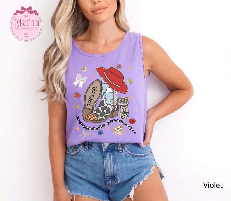 May include: A violet sleeveless tank top featuring a graphic print of a red cowboy hat, a cow-print boot with the name Taylor, a stack of blocks with the letters T, S, and a heart, a bow, and a beaded chain with small floral accents.