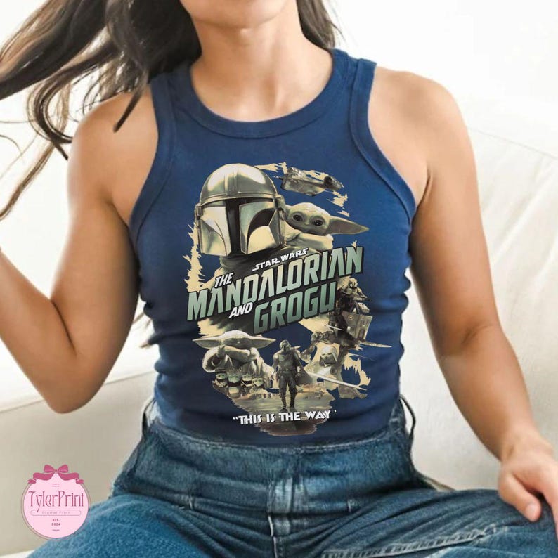 May include: Navy blue tank top featuring a graphic from The Mandalorian series. The design includes the Mandalorian helmet, Grogu, and the text "The Mandalorian and Grogu" and "This is the Way."