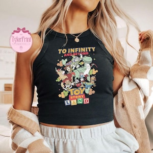 以下が含まれることがあります： 「TO INFINITY AND BEYOND」と「TOY STORY LAND」の文字と、トイ・ストーリーのキャラクターが描かれたカラフルなグラフィックが特徴の黒いタンクトップ。丸いネックラインで袖なしのデザインです。