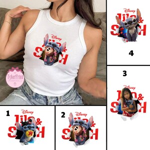 May include: White vest top with a graphic of Stitch from Disney's "Lilo & Stitch" and the text "Lilo & Stitch" in red. The design shows Stitch breaking through a torn hole. The vest top is sleeveless and made of a soft material.