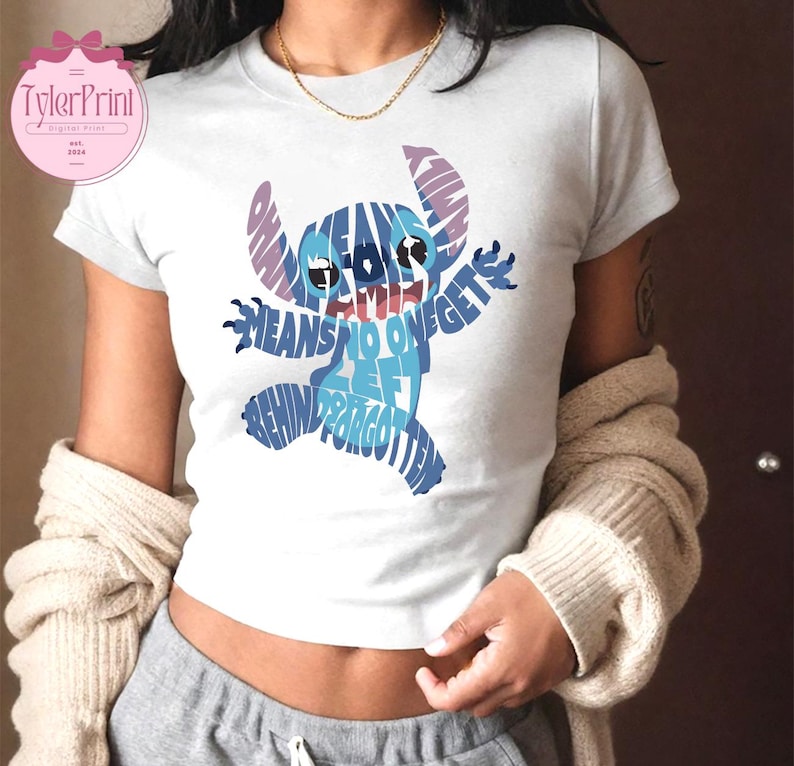 May include: A white t-shirt with a blue Stitch character made of words. The words say "Ohana means family and family means no one gets left behind or forgotten".