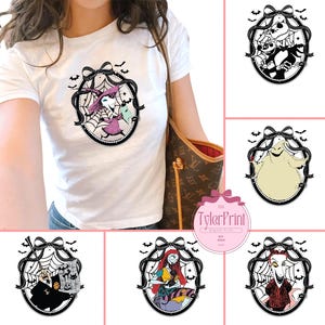 May include: White t-shirt featuring a circular graphic with a witch character, spiderweb, and bats. The graphic is surrounded by a black border and a bow. Additional graphics of characters from the same theme are also shown.
