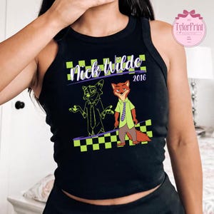 May include: Black vest top with a graphic of Nick Wilde from Zootropolis. The design includes a cartoon fox character in a green shirt and tie, and a sketch of the same character. The text "Nick Wilde 2016" is also present.