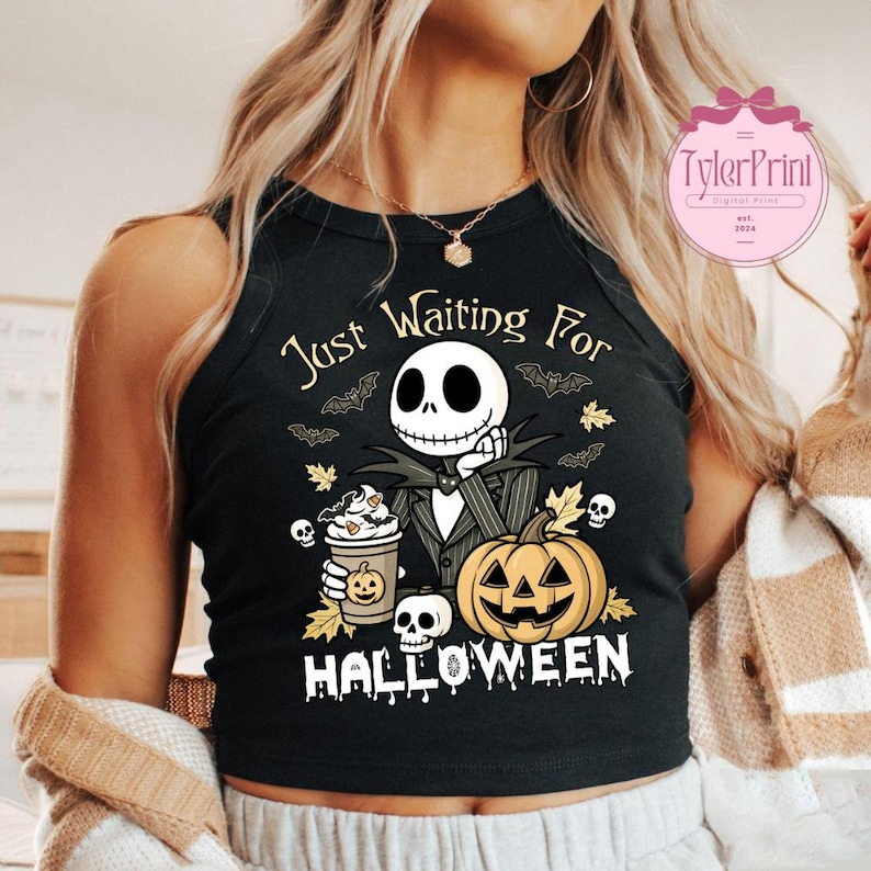 Puede incluir: Camiseta sin mangas negra con un dise&ntilde;o de Halloween. El dise&ntilde;o presenta a Jack Skellington, una calabaza, caf&eacute;, murci&eacute;lagos y el texto "Just Waiting For Halloween". El dise&ntilde;o es en blanco, naranja y amarillo.