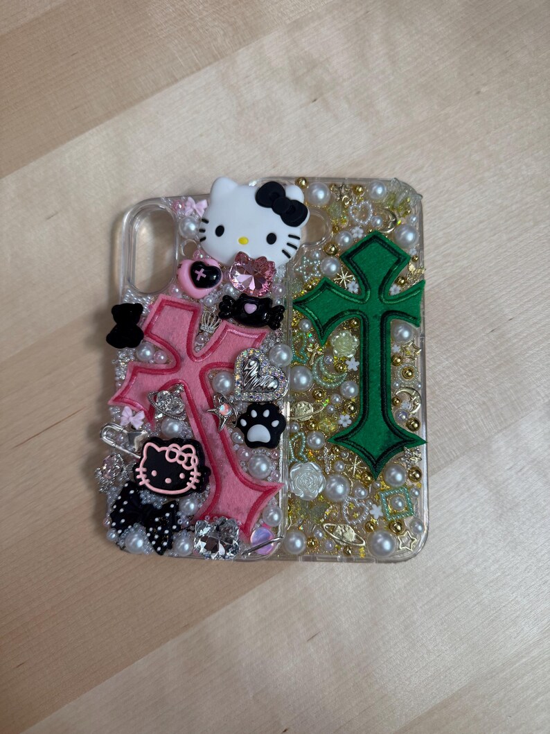 Pode incluir: Uma capa transparente para telefone decorada com cruzes rosa e verde, personagens Hello Kitty, p&eacute;rolas e outros enfeites.