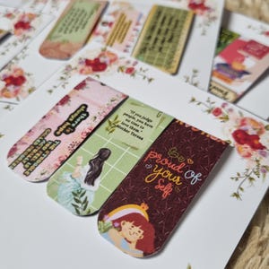 May include: Set of three colourful magnetic bookmarks with inspirational quotes. One bookmark features a quote by Mother Teresa, another says "Be proud of your self", and the third has a floral design.