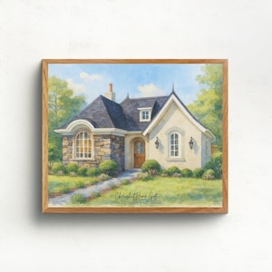 May include: Watercolor painting of a charming cottage with a stone facade and dark gray roof, set in a lush green landscape. The artwork is framed in a light brown wooden frame. The text "Cherished Home Gift" is at the bottom.