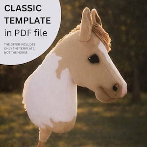 Op de afbeelding: Een pluche stokpaardenkop in crème, bruin en wit, met een bruine manen en zwarte ogen. De tekst "CLASSIC TEMPLATE in PDF file" staat in een witte cirkel. De tekst hieronder luidt "THE OFFER INCLUDES ONLY THE TEMPLATE, NOT THE HORSE."