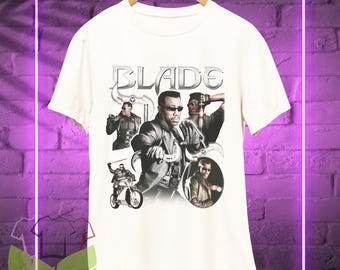 May include: White t-shirt featuring a collage of images of the character Blade from the film Blade. The text "BLADE" is printed in large letters at the top of the shirt.