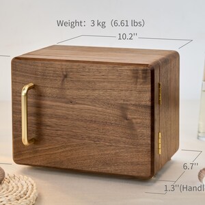 May include: A rectangular wooden storage box with a dark brown wood grain finish, featuring a gold-colored metal handle and hinges. The box measures 10.2 inches wide, 8 inches high, 6.7 inches deep, with a 1.3-inch handle width and weighs 6.61 lbs.