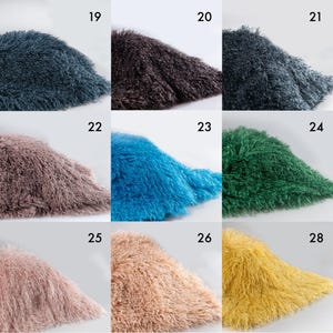 May include: A grid of nine swatches of shaggy, long-pile faux fur fabric in various colors, labeled with numbers 19 through 28. The colors include dark blue, dark brown, charcoal, dusty rose, bright blue, emerald green, light pink, beige, and yellow.