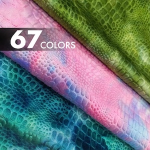 Puede incluir: Primer plano de muestras de tela texturizadas en tonos de verde, rosa, azul y patrones de teñido anudado. La tela tiene un diseño de escamas de reptil. El texto "67 COLORS" se muestra en blanco sobre un fondo negro.