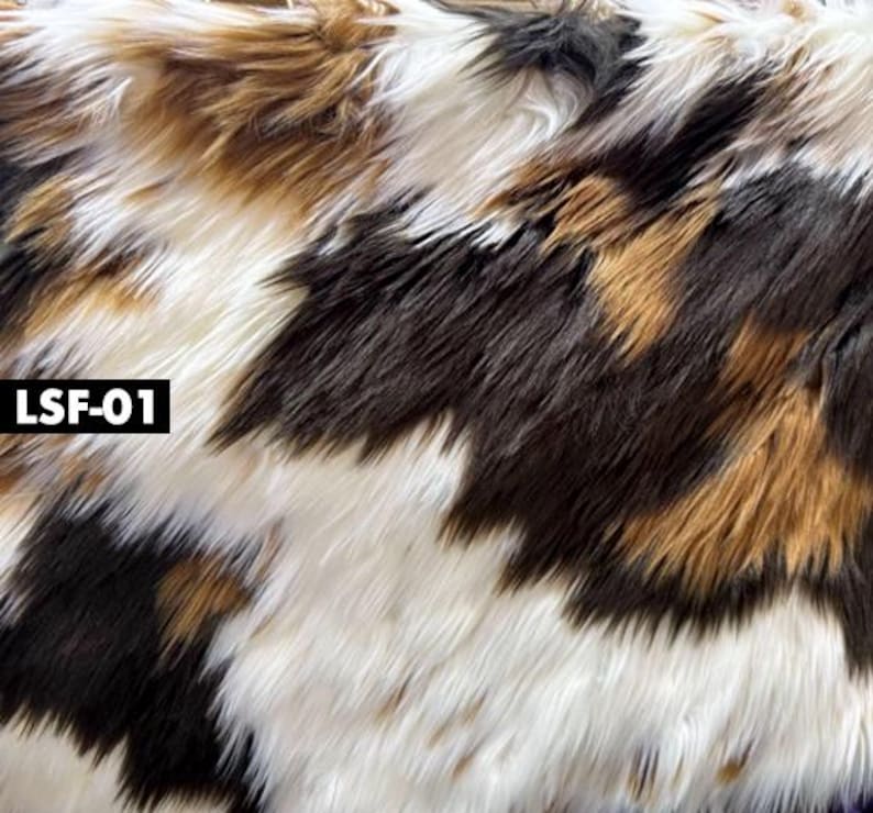 May include: Close-up of faux fur fabric with a pattern of white, brown, black, and tan. The fabric has long, shaggy fibers. The text "LSF-01" is in a black rectangle in the lower left corner.