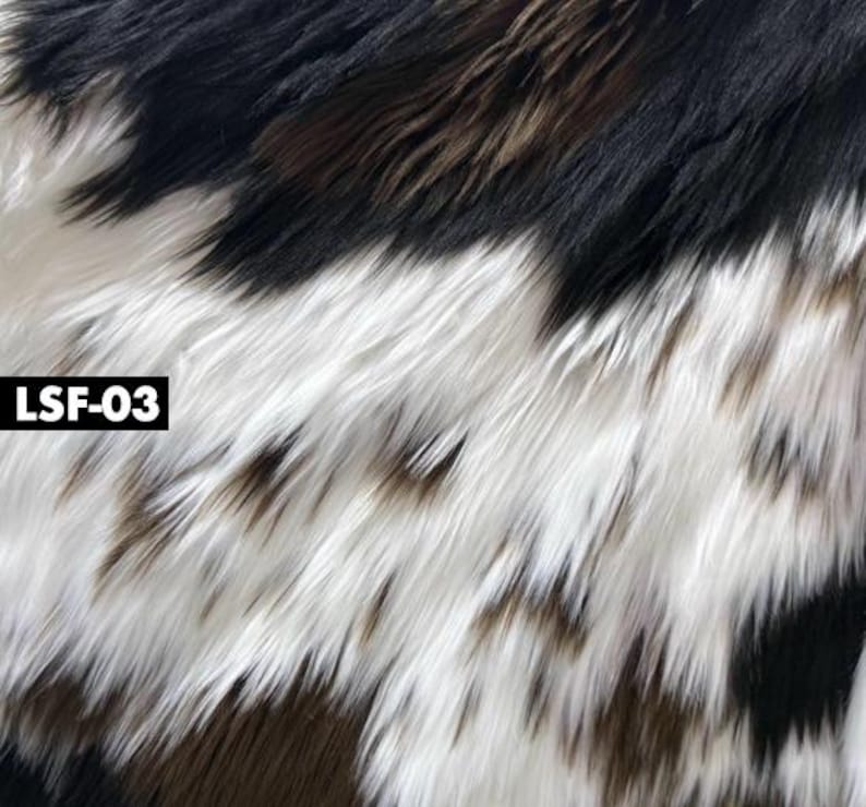 May include: Close-up of faux fur fabric with a mix of black, white, and brown colors. The long, shaggy fibers create a textured appearance. The text "LSF-03" is in a white box in the corner.