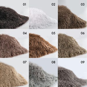 May include: A grid of nine bucket hats made from long-pile faux fur material, each labeled with a number from 01 to 09. The hats are displayed in various colors including black, white, dark brown, light brown, tan, gray, and charcoal tones.