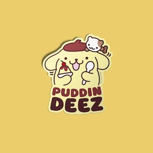 May include: A yellow cartoon dog wearing a brown beret holds a spoon and a small pudding cup with a cherry on top. The dog is labeled "PUDDIN DEEZ" in brown text.