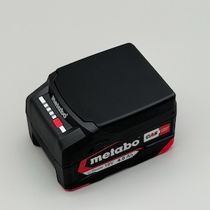 Könnte beinhalten: Schwarzer Metabo Li-Power 18V 4,0 Ah Akku. Der Akku hat ein schwarzes Gehäuse mit roten und weißen Akzenten. Das Metabo-Logo ist auf der Seite sichtbar. Der Akku hat eine Leistungsanzeige.
