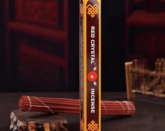 Peut inclure: Une boîte de bâtonnets d'encens Red Crystal avec une étiquette jaune et marron. L'étiquette porte le texte "Red Crystal Incense" et une image stylisée d'une flamme.