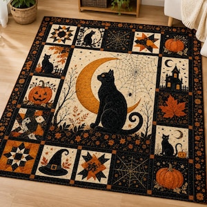 May include: A rectangular quilt featuring a central panel of a black cat sitting before a large orange crescent moon and spiderweb. The border consists of smaller squares displaying black cats, pumpkins, a witch hat, a haunted house, and stars.