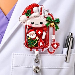 May include: A decorative badge reel shaped like a blood bag with a Santa hat, a green bow with a bell, a Santa Claus figure, a Christmas tree, a heart with a plus sign, a test tube, and a red blood drop icon with the letter A inside.