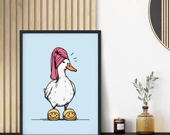 May include: A framed art print featuring a cartoon duck wearing a pink towel on its head and yellow smiley face slippers. The duck is set against a light blue background. The artwork is in a black frame.