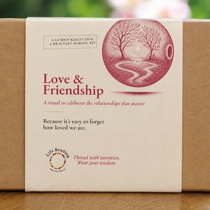 May include: A rectangular brown cardboard box with a white paper sleeve featuring the text Love & Friendship, A guided reflection & bracelet-making kit, A ritual to celebrate the relationships that matter, Because it's easy to forget how loved we are.