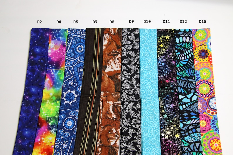 Puede incluir: Una colecci&oacute;n de 10 tiras de tela con diferentes patrones, incluyendo galaxia, arco&iacute;ris, paisley, estampado de animales, hojas y dise&ntilde;os geom&eacute;tricos. Las tiras est&aacute;n etiquetadas como D2, D4, D5, D7, D8, D9, D10, D11, D12 y D15.