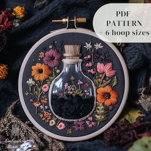 Könnte beinhalten: Stickerei in einem Stickrahmen mit einem Glasfläschchen gefüllt mit schwarzen Blumen und umgeben von bunten Blumen. Der Rahmen liegt auf einem dunklen Stoffhintergrund. Der Text "PDF PATTERN + 6 hoop sizes" befindet sich in der oberen rechten Ecke des Bildes.