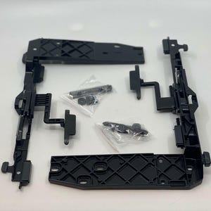Puede incluir: Piezas de plástico negro para un sistema de puerta corredera. Las piezas incluyen una guía, una manija y un rodillo.