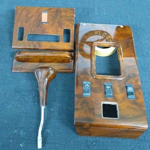 Puede incluir: Cuatro paneles de madera para el interior de un automóvil, con un acabado de madera de color marrón. Los paneles tienen varios recortes para interruptores y otras características. Los paneles son probablemente para un vehículo Mercedes-Benz.