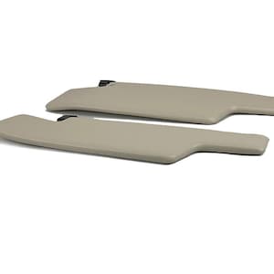 May include: Two beige car sun visors. The visors are made of a soft, textured material and have a simple, rectangular shape.