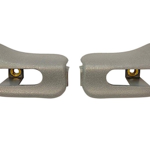 Puede incluir: Dos clips para visera solar de coche de plástico gris con un clip de metal dorado en cada uno.