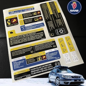 Peut inclure: Une feuille rectangulaire blanche d'autocollants d'avertissement et d'information automobile Saab avec du texte et des icônes jaunes, bleus et noirs. La feuille comprend des instructions pour l'huile, le réfrigérant et les systèmes de refroidissement.