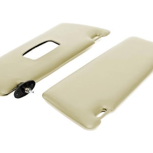 Puede incluir: Un par de viseras para el sol de color beige con clips negros. Las viseras están hechas de un material suave, similar a la tela.