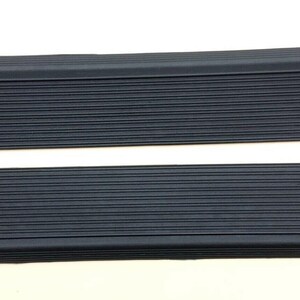 Peut inclure: Deux garnitures de seuil de porte en caoutchouc noir avec une texture nervurée.