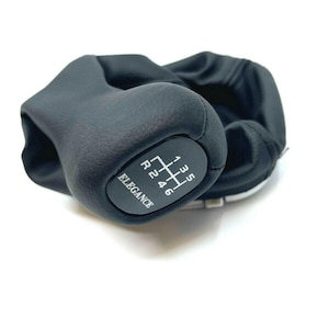 Può includere: Pomello del cambio in pelle nera con uno schema a 6 velocità e la parola "Elegance" stampata sul lato.