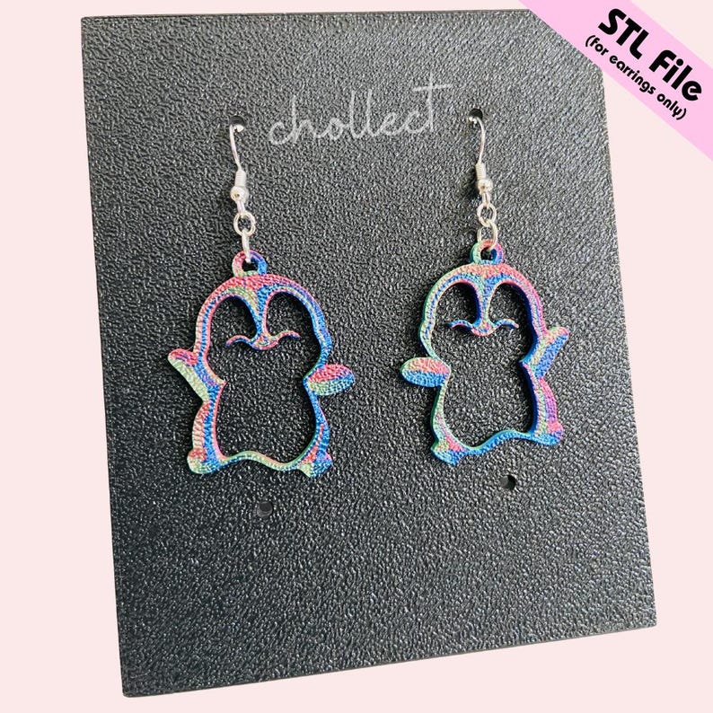 May include: A pair of penguin-shaped earrings with a colourful, rainbow-like pattern. The earrings are hanging from silver-coloured hooks. The text "STL File (for earrings only)" is visible in the upper right corner. The word "chollect" is also visible.