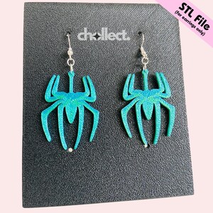 May include: A pair of teal spider-shaped earrings with silver hooks. The earrings have a glittery finish and are displayed on a textured black surface. The text "chcollect" is visible. The upper right corner has the text "STL File (for earrings only)".