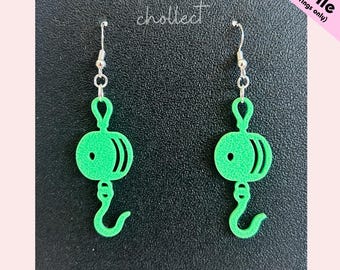 May include: A pair of bright green earrings in a unique design, featuring a circular element with curved lines and a hook shape. The earrings are suspended from silver-colored ear wires. The text "STL File (for earrings only)" is visible.